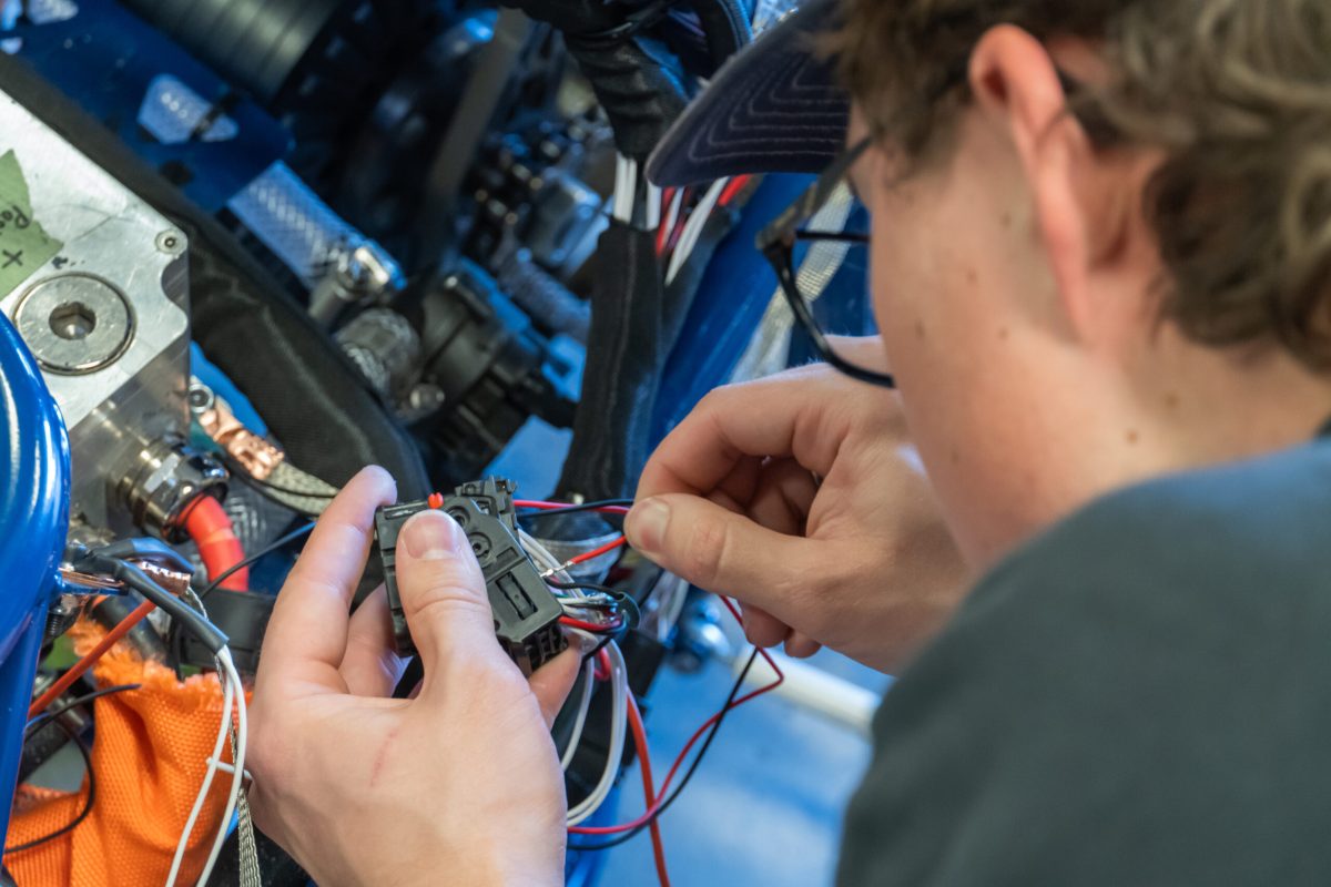 Nittany Motorsports low voltage subsystem member works on pinning a connector to create a wiring harness for the team's car. All pins must be in the correct location on the connector to avoid system malfunctions or damage.